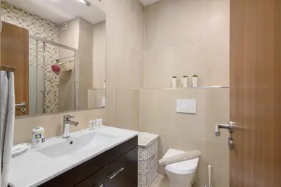 a bathroom with a sink and a toilet and a mirror at T1 com vista mar in Quarteira