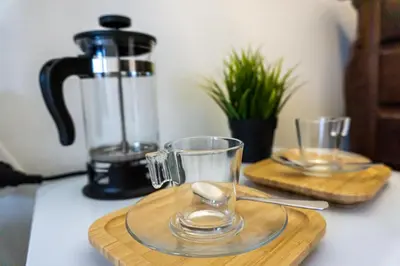 two glasses on a cutting board with a blender on a counter at Aconchego de quartos no centro de Faro in Faro