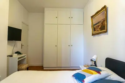 a bedroom with a bed and a white cabinet at Aconchego de quartos no centro de Faro in Faro