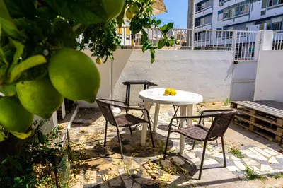 a table and chairs sitting on a patio with a table and chairs at Aconchego de quartos no centro de Faro in Faro