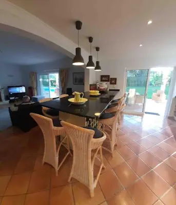 a kitchen with a table and chairs and a dining room at Luxury Private 5 bedroom Villa pool, golf, Algarve in Quarteira