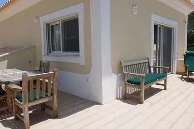 a patio with two chairs and a table and a window at Luxury Private 5 bedroom Villa pool, golf, Algarve in Quarteira