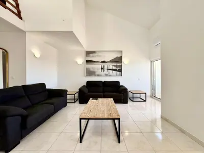 a living room with a couch and a table at Home Out - Vilamoura Beach Apartment - Duplex in Quarteira