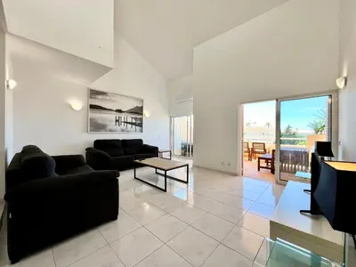 a living room with a couch and a table at Home Out - Vilamoura Beach Apartment - Duplex in Quarteira
