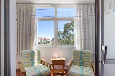 two chairs and a table in front of a window at Apartarment Azur in Albufeira