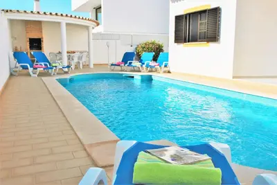 a large swimming pool with chairs and a table at Villa Ibiza by Algarve Vacation in Guia