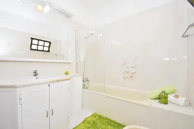 a white bathroom with a tub and a sink at Villa Ibiza by Algarve Vacation in Guia