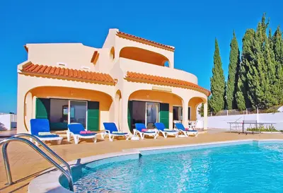 a villa with a swimming pool in front of a house at Villa La Romana by Algarve Vacation in Albufeira