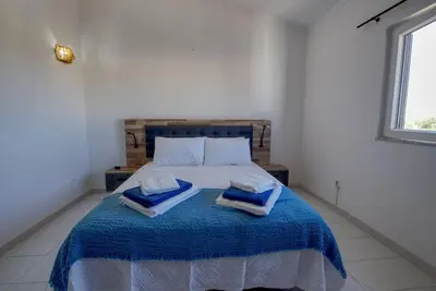 a bedroom with a bed with two towels on it at Townhouse in Quarteira in Quarteira