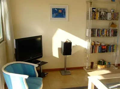 a living room with a tv and a chair and a table at Calm Sunny Apartment near Falésia Beach in Albufeira