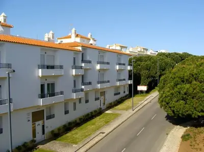an empty street next to a white apartment building at Calm Sunny Apartment near Falésia Beach in Albufeira