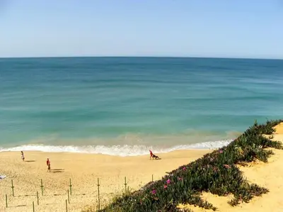 a group of people on a beach near the ocean at Calm Sunny Apartment near Falésia Beach in Albufeira