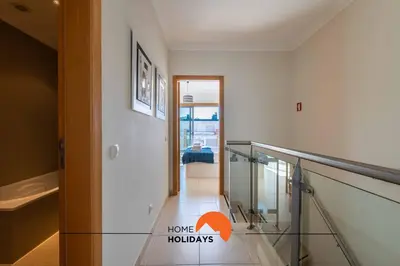 a hallway with a glass railing in a house at #226 Vila LII by Home Holidays in Albufeira