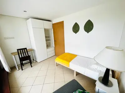 a small bedroom with a bed and a chair at Pe do Lago cosy apartment in Quarteira