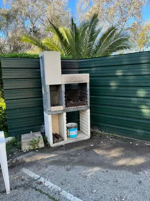 a wooden oven sitting next to a fence at Pe do Lago cosy apartment in Quarteira