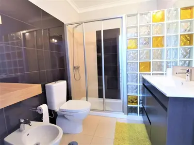 a bathroom with a toilet and a shower and a sink at Casa Tulipa Ferias - Vilamoura in Quarteira
