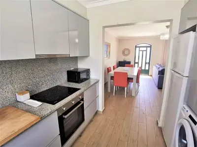 a kitchen with a counter top and a dining room at Casa Tulipa Ferias - Vilamoura in Quarteira