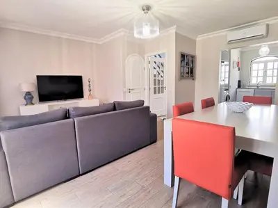 a living room with a couch and a table at Casa Tulipa Ferias - Vilamoura in Quarteira