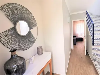 a room with a mirror and a vase on a table at Casa Tulipa Ferias - Vilamoura in Quarteira