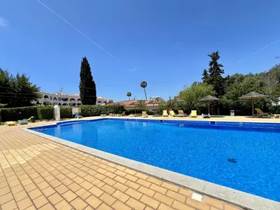 a large swimming pool with blue water in a yard at Albufeira Tropical View 1 With Pool by Homing in Albufeira
