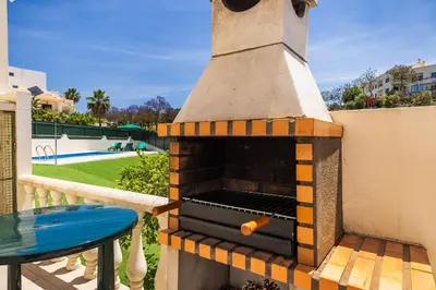 a brick pizza oven on a balcony with a table at Villa Krishan Albufeira - Private Pool in Albufeira