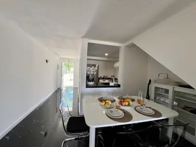 a kitchen with a white table with plates and fruit on it at Albufeira Stylish 3 by Homing in Albufeira