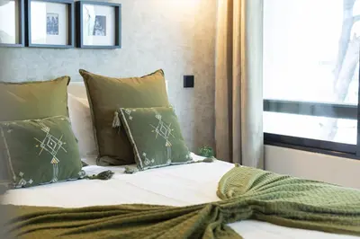 a bedroom with a bed with green pillows and a window at Dona Marieta House in Vilamoura