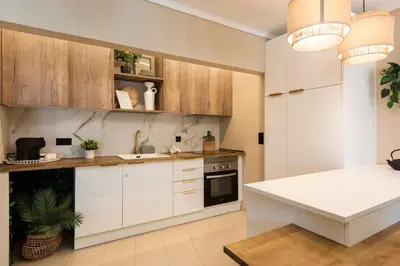 a kitchen with white cabinets and a white table at Dona Marieta House in Vilamoura