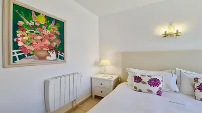 a bedroom with a bed with a painting on the wall at Marina parque CD 68 - Cleverdetails - private pool, few steps to the marina in Vilamoura