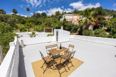 a table and chairs on the roof of a house at Casa Ladeira in Loulé