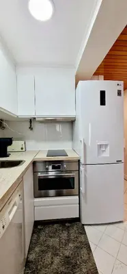 a kitchen with a stove and a white refrigerator at Victory Village Club,Quinta do Lago in Loulé