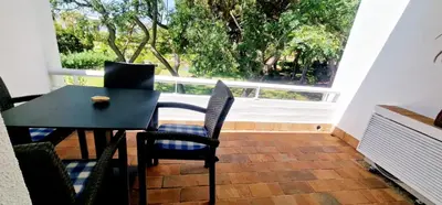 a black table and chairs in a room with a window at Victory Village Club,Quinta do Lago in Loulé