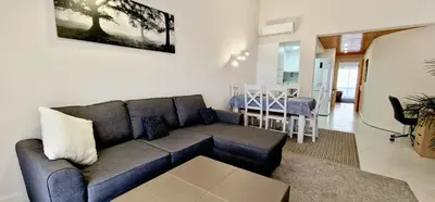 a living room with a couch and a dining room at Victory Village Club,Quinta do Lago in Loulé