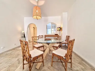 a dining room with a glass table and chairs at Ancão beach duplex with private garden in Almancil