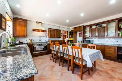 a kitchen with a table and chairs and a sink at AL Monte Lusitano in Loulé