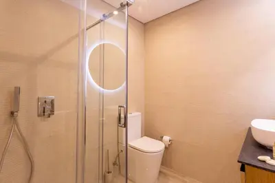 a bathroom with a shower with a toilet and a sink at Villa Golden Falésia by HelloVacations in Albufeira