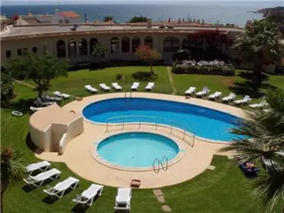 a large swimming pool with chairs and a building at Perfect ApartHotel 1 Bedroom in Olhos de Água