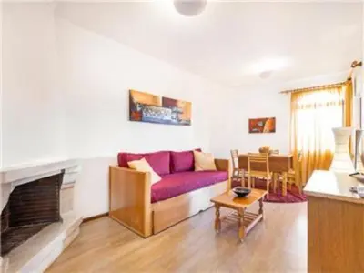 a living room with a purple couch and a fireplace at Perfect ApartHotel 1 Bedroom in Olhos de Água