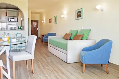 a room with a bed and a table and chairs at Perfect ApartHotel Apartments 1 Bedroom in Albufeira