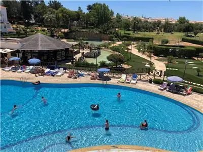 a large swimming pool with people in the water at Perfect ApartHotel Apartments 1 Bedroom in Albufeira