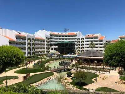 a resort with a large building in the background at Perfect ApartHotel Apartments 1 Bedroom in Albufeira