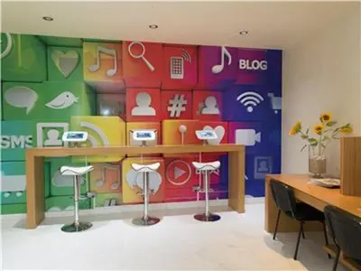 a room with a colorful wall with a table and stools at Perfect ApartHotel Apartments 1 Bedroom in Albufeira