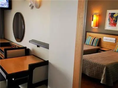 a small room with a bed and a table and a desk at Exciting Albufeira Studio in Albufeira