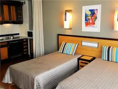 a hotel room with two beds and a kitchen at Exciting Albufeira Studio in Albufeira