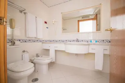 a bathroom with a toilet and a sink and a mirror at Brilliant Apartments 1 Beedroom in Quarteira