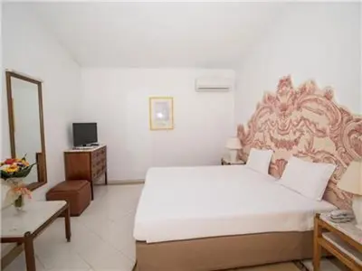 a bedroom with a large white bed and a table at Brilliant Apartments 1 Beedroom in Quarteira