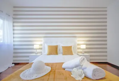 a bedroom with a white bed with two hats on it at Beach Side Apartment in Albufeira