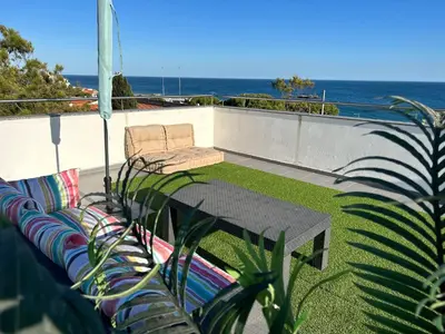 a patio with a table and chairs on a roof at Beach Side Apartment in Albufeira
