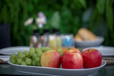 a plate of apples and grapes on a table at Sun & salt Apartment in Albufeira
