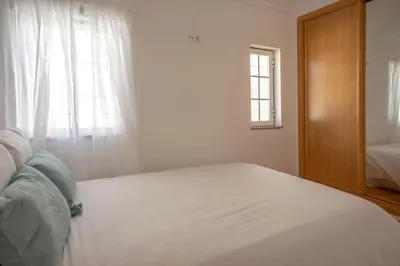 a white bed in a bedroom with a window at Summer Villa in Albufeira
